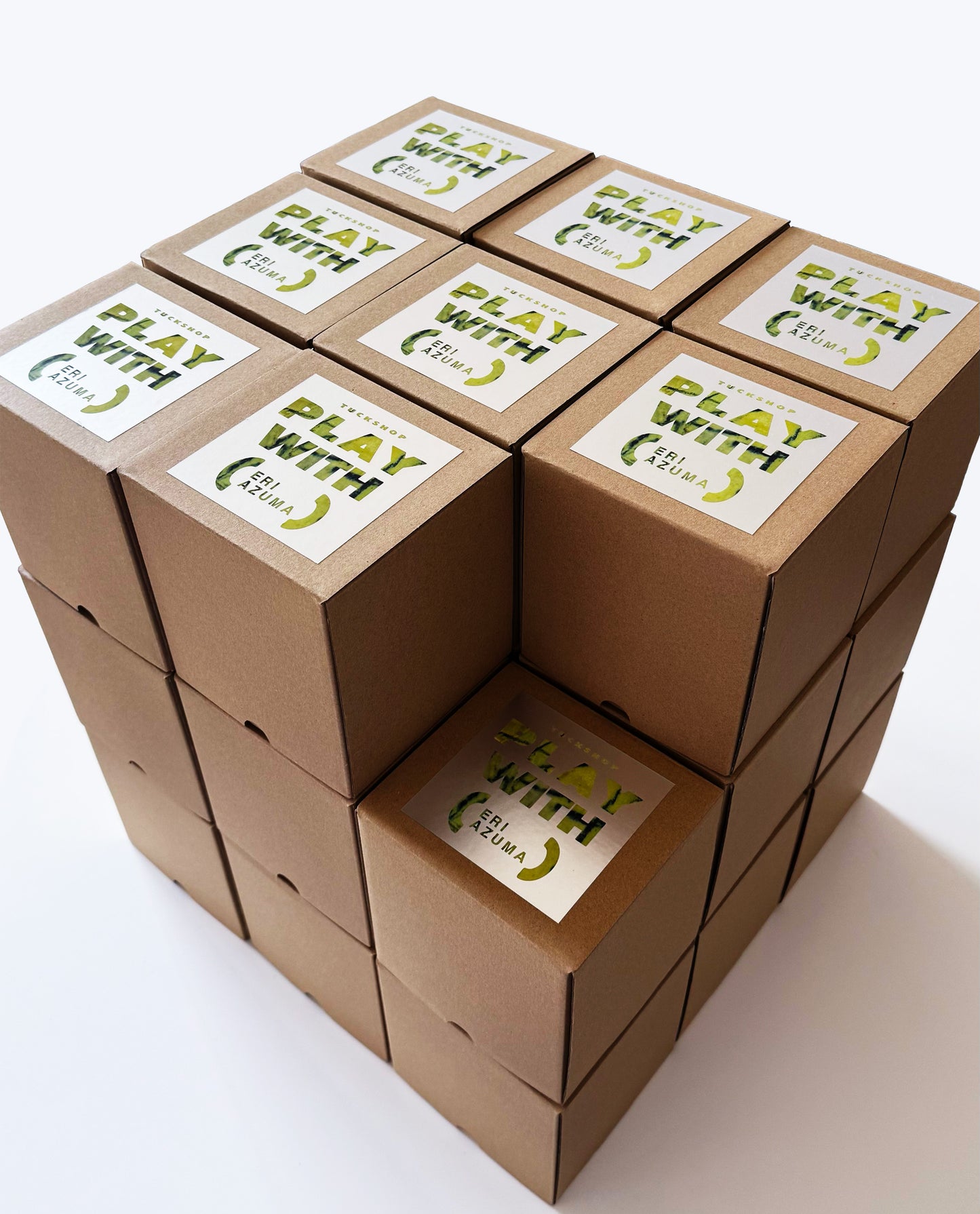 Stacked brown boxes featuring the 'PLAY WITH (UNIFORM)' logo, part of a creative collaboration project.