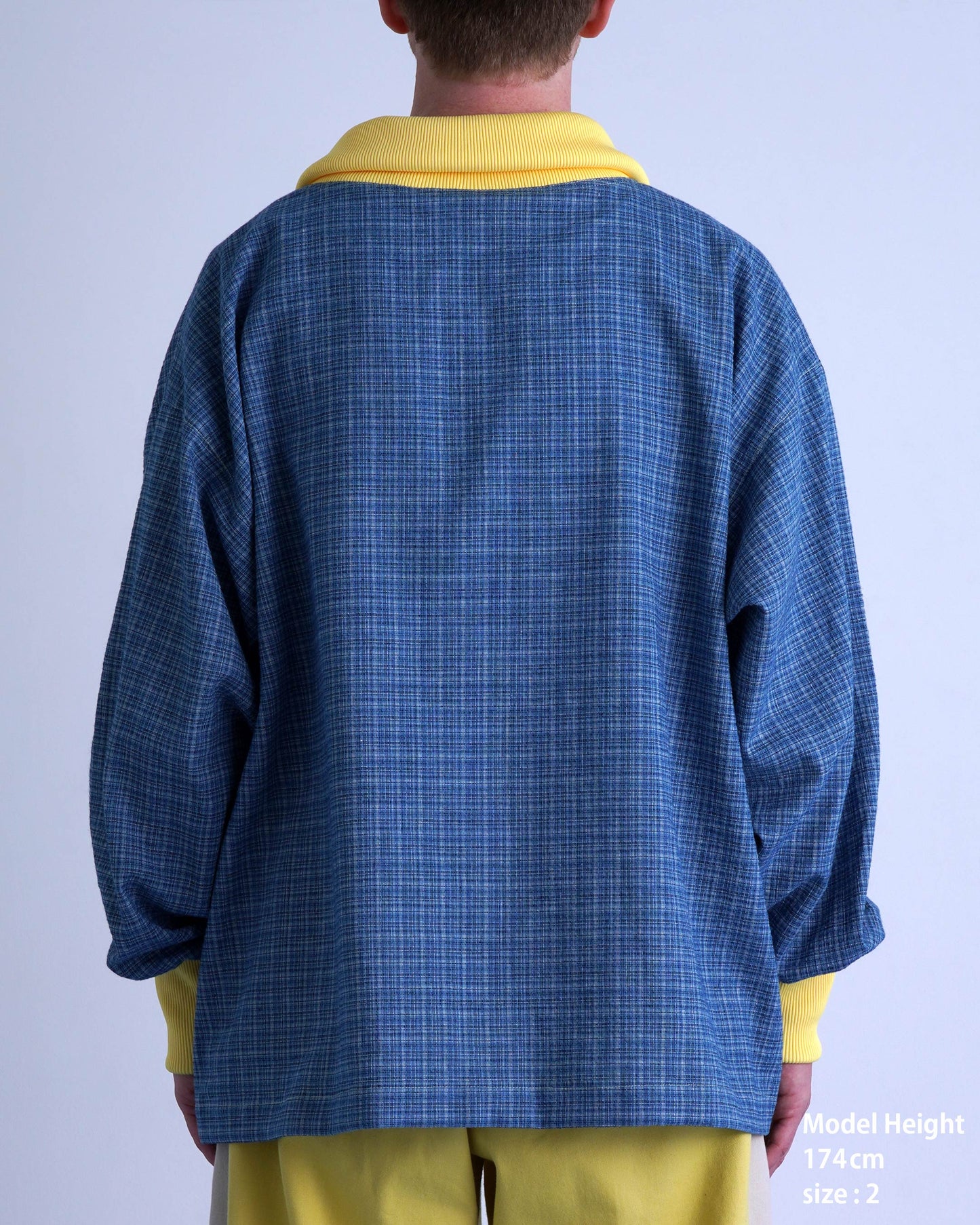 FOOTBALL POLO PULLOVERの後ろ姿、チェック柄とイエローの襟が特徴的なデザインの衣服。