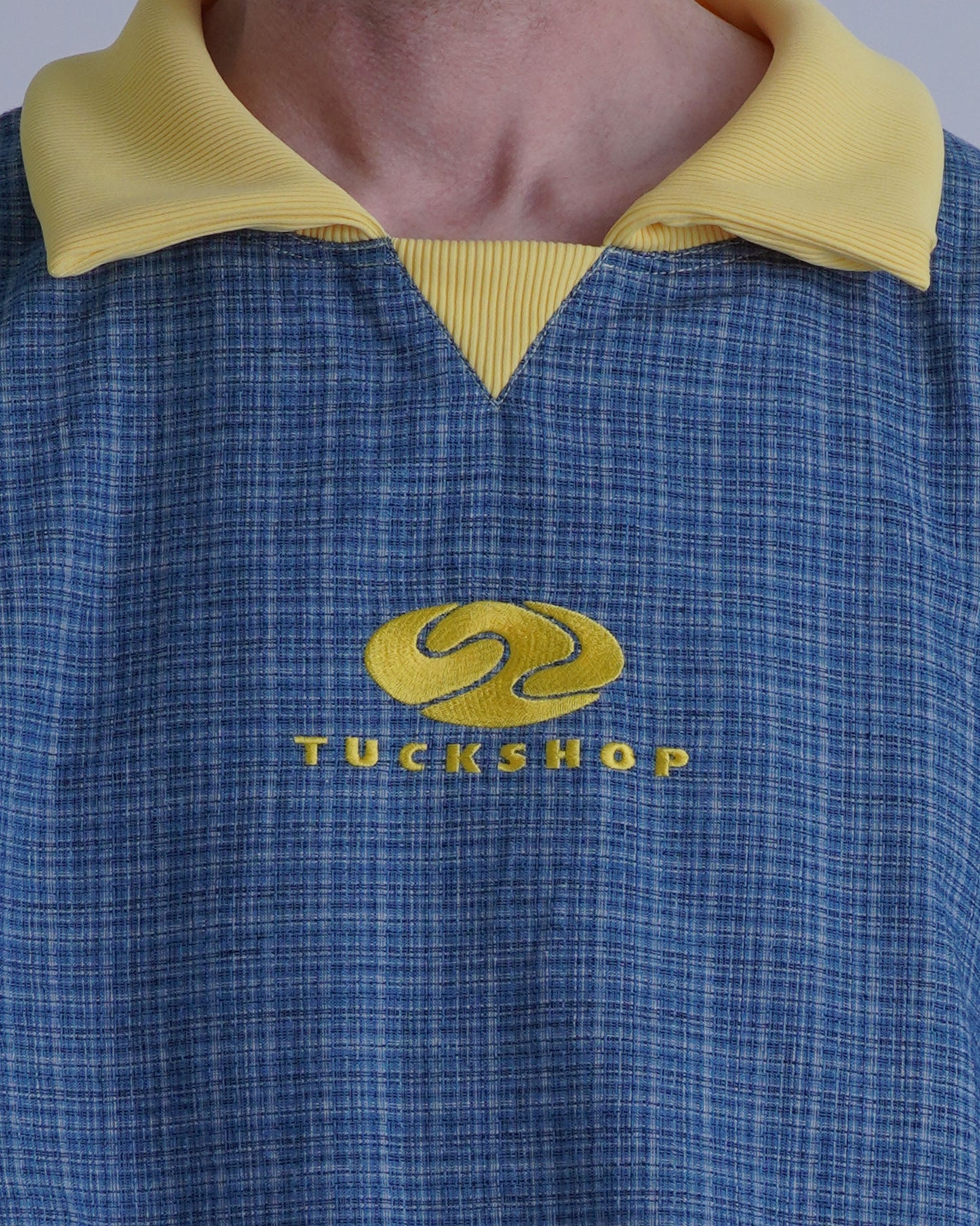 FOOTBALL POLO PULLOVERの襟とロゴの詳細を描写した画像