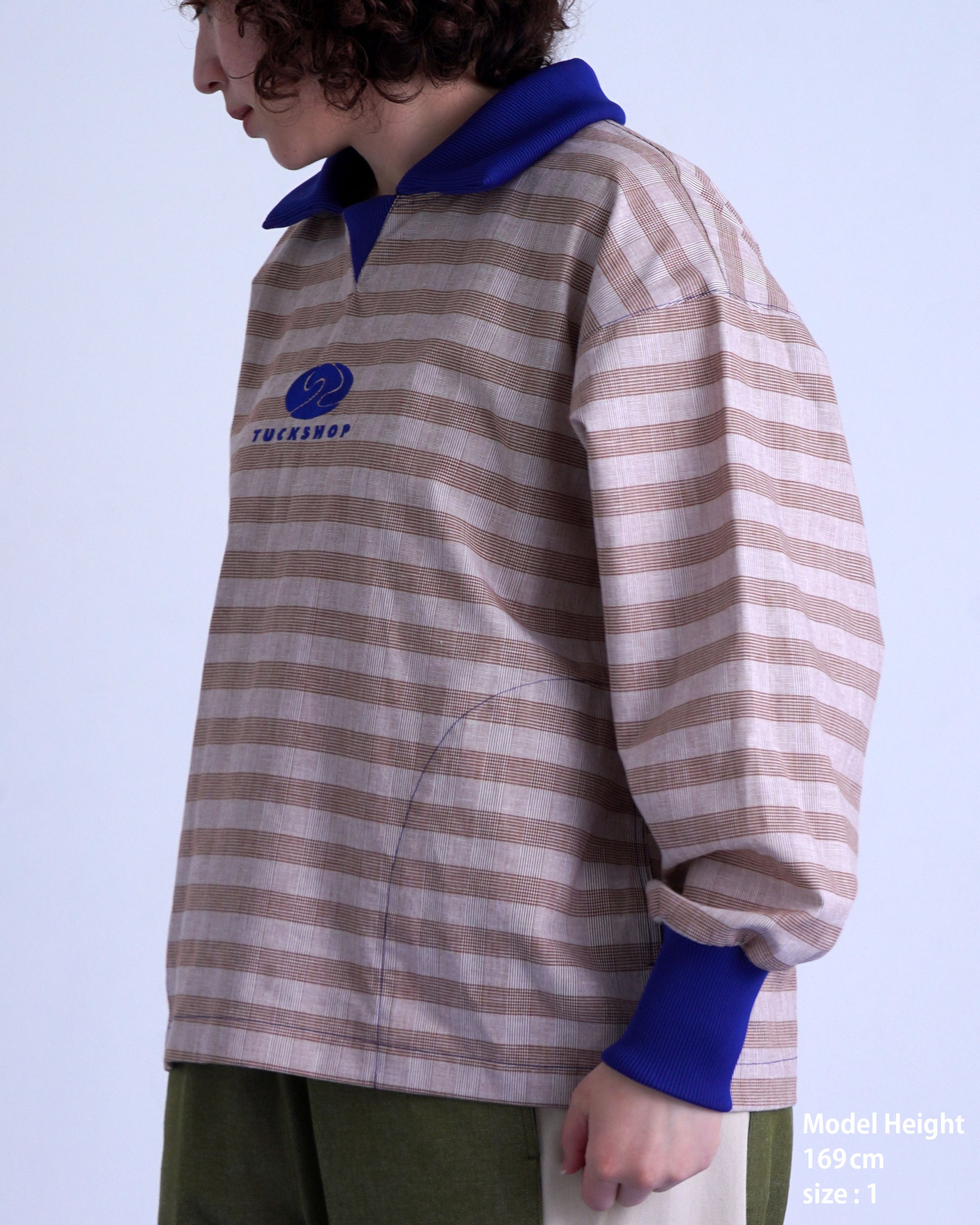 FOOTBALL POLO PULLOVERのストライプデザインのサイドビュー、青い襟と刺繍ロゴが特徴のプルオーバー