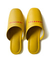 Yellow faux leather indoor slippers with logo print for comfortable home wear.