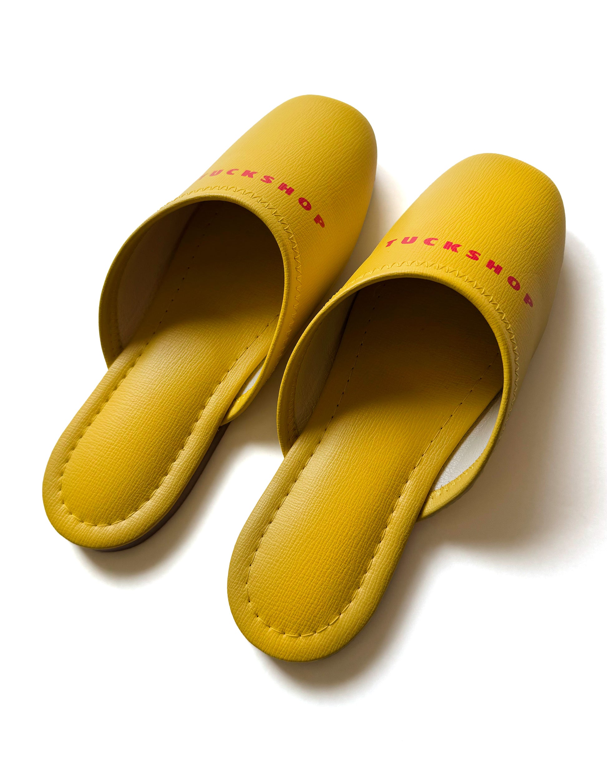 Yellow faux leather slippers with logo print, indoor use, comfortable design, stylish and modern footwear.